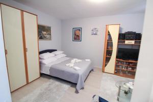 a small bedroom with a bed and a mirror at Apartman Alka in Sinj