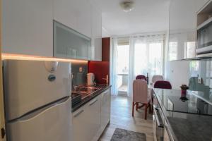 a kitchen with a refrigerator and a table with chairs at Apartman Alka in Sinj