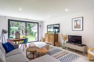 Una sala de estar con un sofá y un televisor. en Villa Sterne - maison vue mer exceptionnelle - Fréhel, en Fréhel