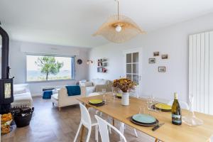 Un comedor y una sala de estar con mesa y sillas. en Villa Sterne - maison vue mer exceptionnelle - Fréhel, en Fréhel 15 fotos más