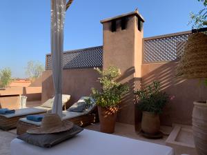 un patio con 2 salones y macetas en Riad UP en Marrakech