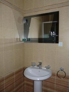 BULGARI melnik في ميلنيك: حمام مع حوض أبيض ومرآة