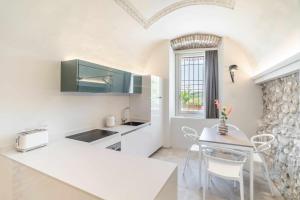 a kitchen and dining room with a table and chairs at Palazzo Trevignane appartamento La Saletta Verde in San Felice del Benaco