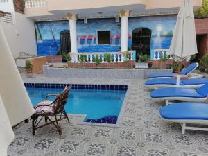 a patio with chairs and a swimming pool at Luxor palace Apartments in Luxor