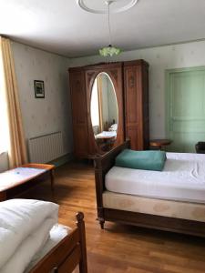 1 Schlafzimmer mit 2 Betten und einem großen Spiegel in der Unterkunft Maison d'Argonne in Brécy-Brières