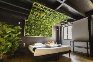 1 dormitorio con 1 cama con techo verde en Kinabalu - Domaine Tropical, en Saint-Aignan
