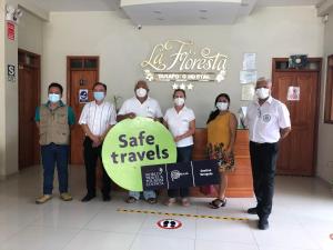 a group of people standing in a room with a sign at La Floresta Tarapoto Hostal in Tarapoto