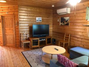 sala de estar con TV y mesa en Aarnitupa, cottage by lake Kylmäluoma, 