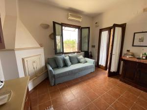 een woonkamer met een bank en een raam bij Villetta a Corigliano D'Otranto in Melpignano