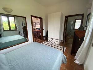 una camera con un letto e un grande specchio di Villetta a Corigliano D'Otranto a Melpignano