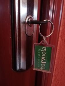a red door with a key tag on it at Apartmani Bambola in Višegrad