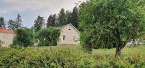 une maison au milieu d'un champ avec un arbre dans l'établissement Vääpeli, à Hämeenlinna