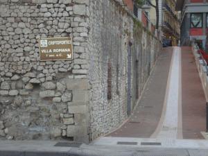 a stone wall with a sign on the side of it at Anfiteatro apartment in Formia