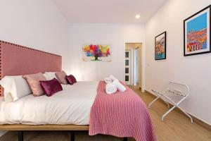 a bedroom with a large bed with a pink blanket on it at Nine O'Clock Metrosol by Valcambre in Seville