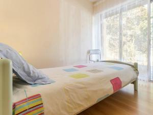 a bed with a colorful comforter in a room with a window at Gîte Saint-Brevin-les-Pins, 4 pièces, 4 personnes - FR-1-306-1049 in Saint-Brevin-les-Pins