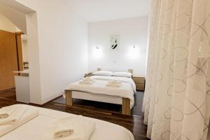 2 letti in una camera con pareti bianche di Cozy House Ania a Laghi di Plitvice