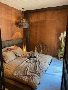 1 dormitorio con 1 cama con pared de madera en Cozy beach house Jurmala, en Jūrmala