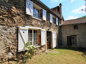 布萊勒的住宿－Gîte Blesle, 3 pièces, 4 personnes - FR-1-582-14，一座古老的石头房子,设有白色的门窗