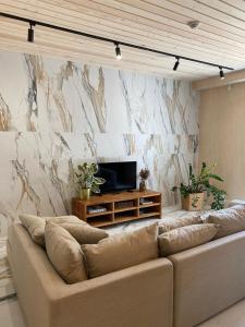 a living room with a couch and a tv at Cozy beach house Jurmala in Jūrmala