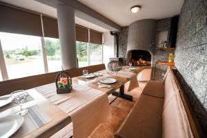 a dining room with two tables and a fireplace at Villa Vucipolje in Posušje