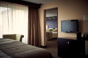 a hotel room with a bed and a flat screen tv at Van der Valk Hotel Emmeloord in Emmeloord