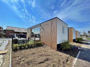 a small house with a wooden facade at New Dahlia in Bredene
