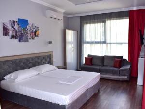 ein Schlafzimmer mit einem Bett und einem Sofa in der Unterkunft Hotel Number One in Gjirokastër