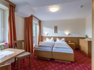 a hotel room with a bed and a desk at Apartments Rosenhof in Mayrhofen