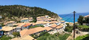 een groep huizen op een heuvel naast de oceaan bij Villa Spiros in Ayios Nikitas