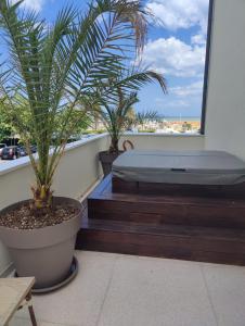 a bedroom with a bed and palm trees on a balcony at Hotel Ambassador in Rimini