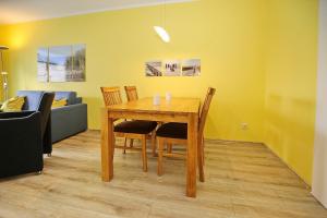 a dining room table with chairs and a couch at Dünenblick Wohnung 42 in Boltenhagen