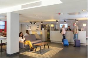 a group of people standing in a lobby with luggage at Holiday Inn Express Southwark, an IHG Hotel in London