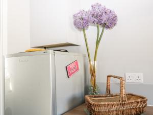 a vase of purple flowers sitting next to a refrigerator at Seagull Cottage in Bude