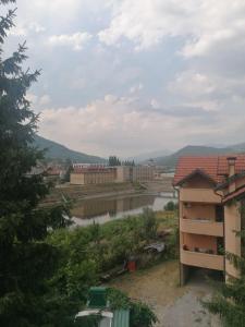 vistas a un río con edificios en el fondo en Apartmani Bambola, en Višegrad