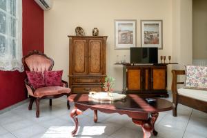 uma sala de estar com uma mesa de centro e uma televisão em ViLLA127 em Atenas