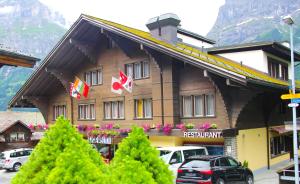 un hotel con coches aparcados delante en Hotel Eigerblick, en Grindelwald