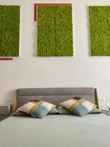1 cama con 2 almohadas en una habitación con plantas verdes en B&B Monteverdi L'Arancio, en Florencia