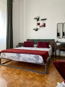 una camera da letto con un letto con cuscini rossi di B&B Monteverdi L'Arancio a Firenze