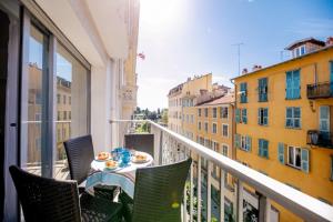 a table on a balcony with a view of buildings at SUEDE 2 AP4208 By Riviera Holiday Homes in Nice
