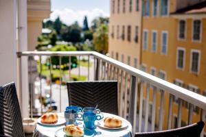 a table with plates of food on a balcony at SUEDE 2 AP4208 By Riviera Holiday Homes in Nice +4 photos