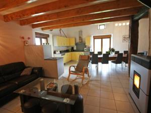 een woonkamer en een keuken met een bank en een tafel bij Gîte Harsault, 5 pièces, 9 personnes - FR-1-589-79 in Bains-les-Bains