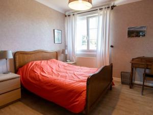 ein Schlafzimmer mit einem Bett mit einer orangefarbenen Bettdecke und einem Fenster in der Unterkunft Gîte Étain, 4 pièces, 6 personnes - FR-1-585-57 in Étain