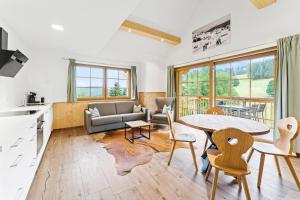 a kitchen and living room with a table and chairs at SCHWARZENBACH - Apartments & Rooftop Pool in Feldberg