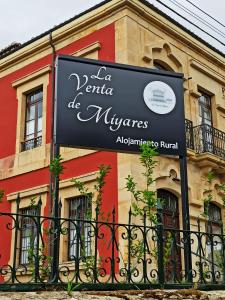 un signo de aederaria de mijennes frente a un edificio en La Venta de Miyares - Casa de Indianos, en Piloña