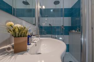 uma casa de banho com um lavatório branco e um chuveiro em Bosa Queen House em Bosa