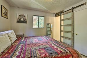 een slaapkamer met een bed met een kleurrijke deken bij Direct Beach Access Grand Lake Cabin with Deck! in Grand Lake