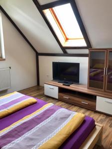 Schlafzimmer im Dachgeschoss mit 2 Betten und einem Flachbild-TV in der Unterkunft Na Červené louce relax 1 in Cheb
