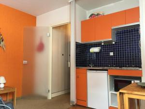 uma cozinha com armários laranja e preto em Studio Montgenèvre, 1 pièce, 2 personnes - FR-1-445-154 em Montgenèvre