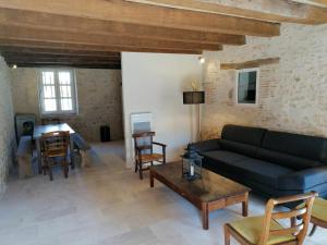 a living room with a couch and a table at Gîte familial au calme avec parc et jardin, pour 8 personnes, près d’un château historique - FR-1-586-15 in Ainay-le-Vieil