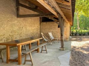 a wooden table and chairs on a patio at Gîte élégant avec jardin privé, climatisation et parking à Ainay-le-Vieil - FR-1-586-7 in Ainay-le-Vieil